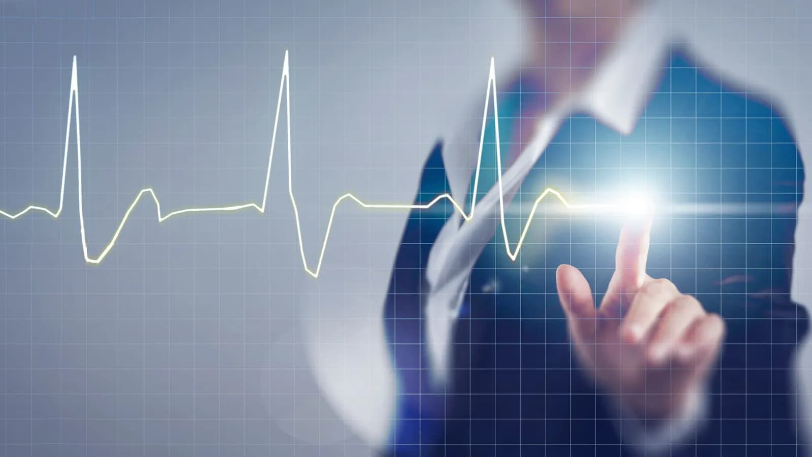 A person in a suit touching a glowing heartbeat line on a grid-patterned screen with their fingertip